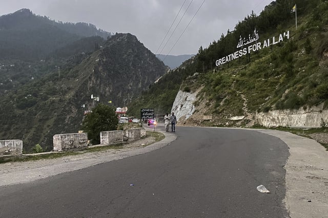 Local residents walk on a highway near on the Line of Control, the de facto border dividing Pakistan and Indian Kashmir, in Chilhana, some 45 kilometres (27 miles) from Muzaffarabad, the capital of Pakistan controlled Kashmir, Thursday, May 1, 2025. (AP Photo/M.D. Mughal)