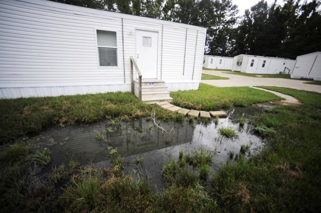 Fetid water pools outside a mobile home in Hayneville in Lowndes County, Ala., in 2022. 