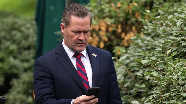 National Security Advisor Michael Waltz looks at his phone as he prepares for a TV interview at the White House on May 1, 2025 in Washington, DC. This week marks the first 100 days of U.S. President Donald Trump’s second term.