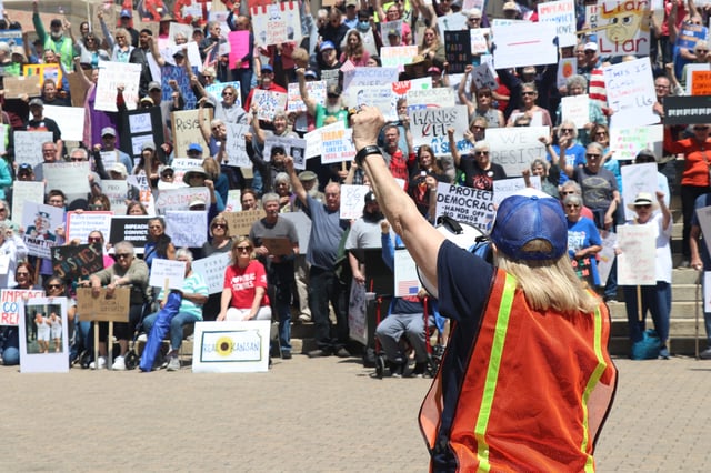 50501 organizer Christy Allen addresses protesters with a bullhorn outside of the Kansas Statehouse.