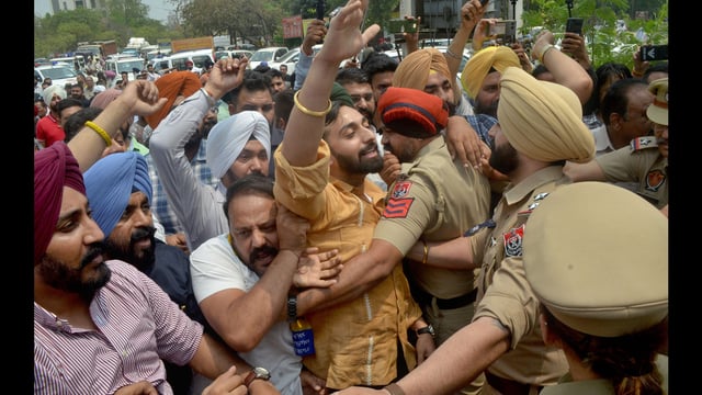 Police stopping AAP leaders from heading towards the BJP office in Ludhiana. (Gurpreet Singh/HT)