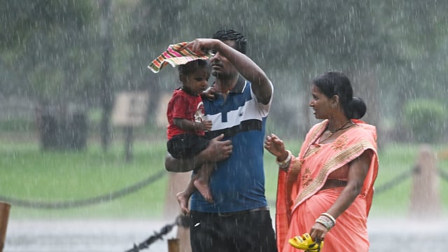 Visitors at Kartavya Path amid rain in New Delhi. The IMD also warned of hailstorm damaging crops and injuring people/cattle standing at open spaces.