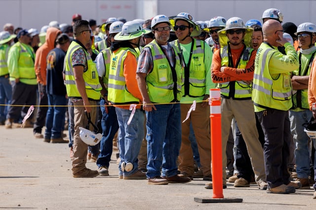 Construction workers and electricians wait in line during a lunch break, as they build California's largest battery storage facility on a 43-acre site in Menifee, California, U.S., March 28, 2024.  REUTERS/Mike Blake/File Photo