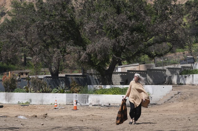 Kathryn Frazier visits her fire-damaged property, which she plans to rebuild, in Altadena, Calif., on Tuesday, April 22, 2025. (AP Photo/Damian Dovarganes)