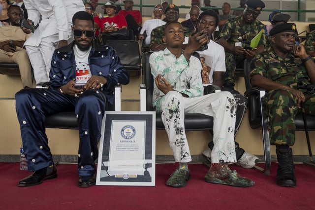 Kanyeyachukwu Tagbo-Okeke, Centre, a 15 year-old autistic artist who won the Guinness World Record for the largest art canvas, attends the World Autism Day in Abuja, Nigeria, Wednesday, April 2, 2025. (AP Photo/David Durowaiye)