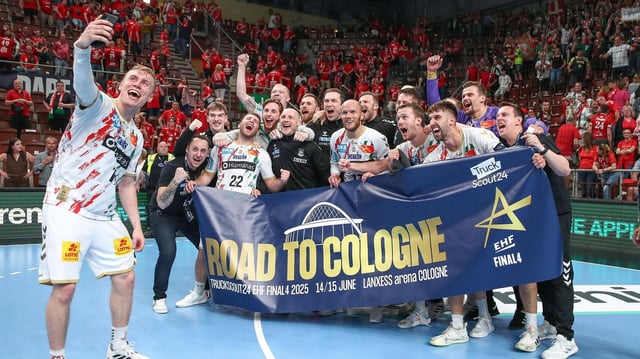 Magdeburg jubelt nach Spielende gegen Veszprem und macht ein Selfie mit übergroßer Fahrkarte nach Köln