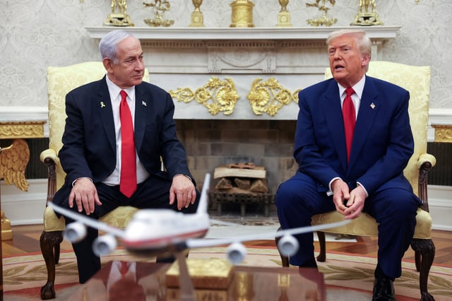 U.S. President Donald Trump talks to Israeli Prime Minister Benjamin Netanyahu during a meeting where Trump announced nuclear talks with Iran, Washington, U.S., April 7, 2025. REUTERS/Kevin Mohatt/File Photo
