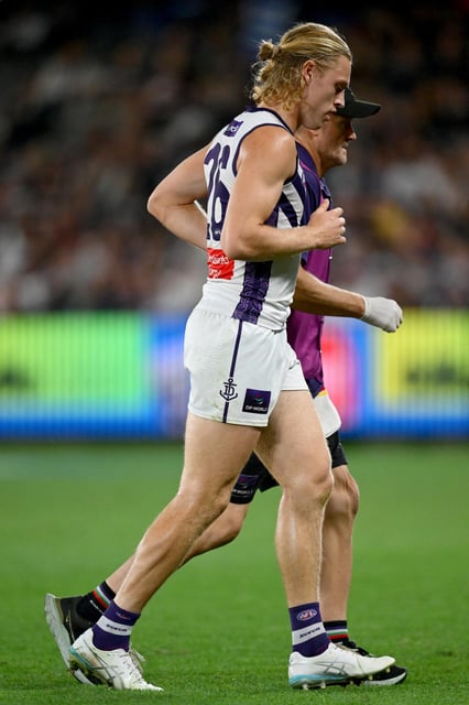Hayden Young is assisted from the field.