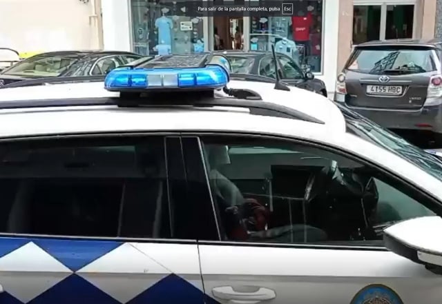 Un coche de la Policía Local de A Coruña delante de la sucursal que sufrió el robo.