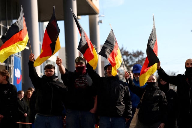 Supporters of the Alternative for Germany party (AfD) wave flags as they take part in an AfD campaign rally in Hohenschoenhausen, Berlin, Germany, February 22, 2025. REUTERS/Christian Mang/File Photo