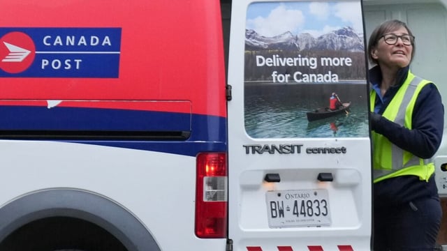A Canada Post letter carrier prepares to deliver mail in Toronto on Dec. 17, 2024. Canada Post workers could go on strike again as soon as May 22 if a deal between the union and the postal agency isn't reached before then.