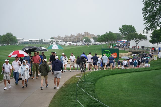 May 2, 2025; McKinney, Texas, USA; Spectators make their way up the 18th green as the course is being evacuated because of impending weather during the second round of the THE CJ CUP Byron Nelson golf tournament. Mandatory Credit: Raymond Carlin III-Imagn Images