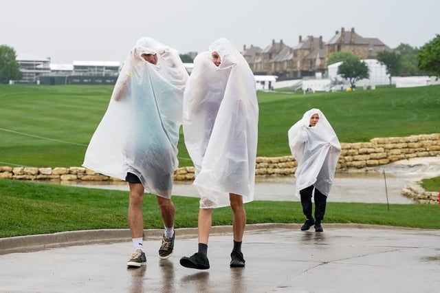 May 2, 2025; McKinney, Texas, USA; Spectators make their way up the 18th green as the course is being evacuated because of impending weather during the second round of the THE CJ CUP Byron Nelson golf tournament. Mandatory Credit: Raymond Carlin III-Imagn Images