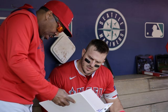 Los Angeles Angels' Mike Trout talks with batting coach Johnny Washington in the dugout before a baseball game against the Seattle Mariners, Wednesday, April 30, 2025, in Seattle. (AP Photo/John Froschauer)