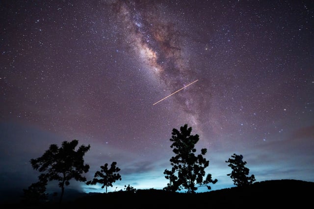 A flight-illuminated path and the Milky Way are appearing in the night sky during the Eta Aquarids meteor shower, which is peaking in Ratnapura, Sri Lanka, on May 5, 2024. The Eta Aquarids Meteor Shower is an annual event caused by Earth passing through debris left behind by Halley's Comet. Named after the constellation Aquarius, these meteors are streaking across the sky at high speeds, creating a dazzling display of shooting stars. Best observed in the predawn hours away from city lights, it is a mesmerizing celestial event cherished by skywatchers worldwide. (Photo by Thilina Kaluthotage/NurPhoto via Getty Images)