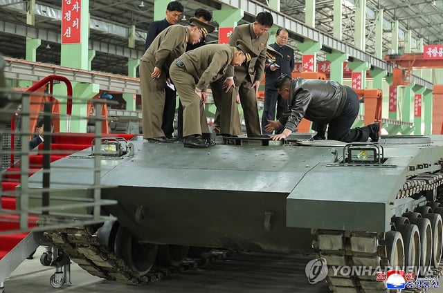 North Korean leader Kim Jong-un (R) inspects a tank on his knees inside a factory in this undated photo released by the North's official Korean Central News Agency on May 4, 2025. The name and location of the factory was not disclosed. (For Use Only in the Republic of Korea. No Redistribution) (Yonhap)