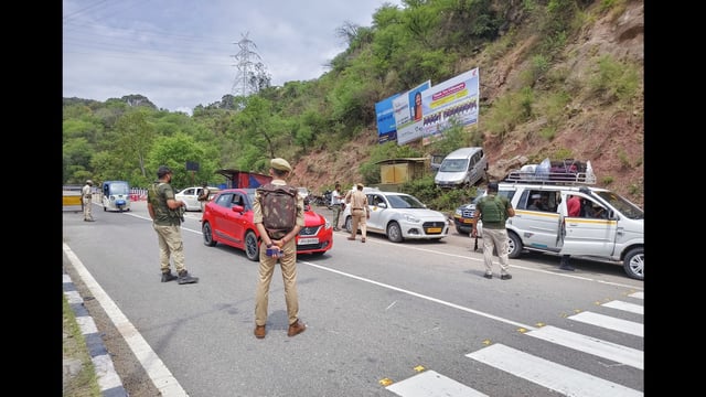 Jammu and Kashmir police personnel check vehicles at the Phalata Naka point on National Highway 1, in Udhampur on Saturday. (ANI Photo)