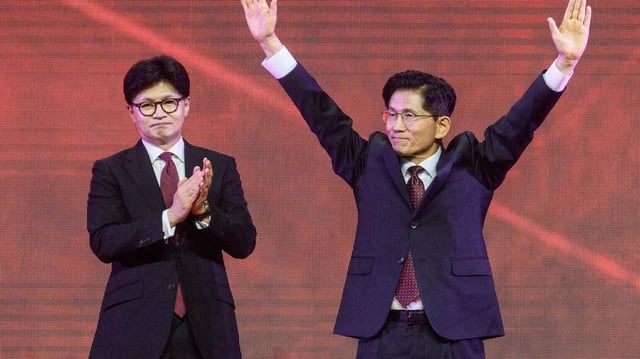 Former labor minister Kim Moon-soo, right, celebrates next to ex-party chief Han Dong-hoon after winning the final race to choose South Korea’s conservative People Power Party’s candidate for the upcoming presidential election, during a national convention of the party in Goyang on Saturday, May 3, 2025. (Anthony Wallace/AFP/Getty Images/TNS)