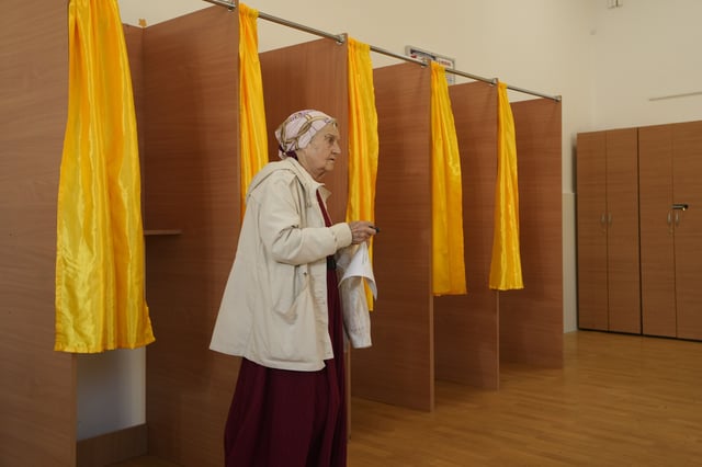 A woman exits after casting her vote in the first round of the presidential election redo in Bucharest, Romania, Sunday, May 4, 2025. (AP Photo/Vadim Ghirda)