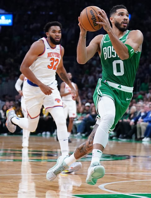 Boston Celtics forward Jayson Tatum (0) returns the ball to score against New York Knicks center Karl-Anthony Towns (32) in the first quarter at TD Garden.