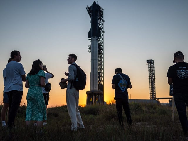 Visitors look at the SpaceX Starship as it sits on a launch pad at Starbase near Boca Chica, Texas, ahead of the 2024 Starship Flight 5 test.