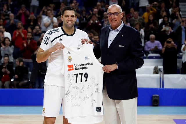 El que fuera pívot del Real Madrid Felipe Reyes recibe una camiseta de manos del exjugador Rafael Rullán con motivo del homenaje recibido por convertirse en el jugador con más partidos disputados en la historia de la Liga, antes del inicio del partido ante el Kirolbet Baskonia en febrero de 2019.