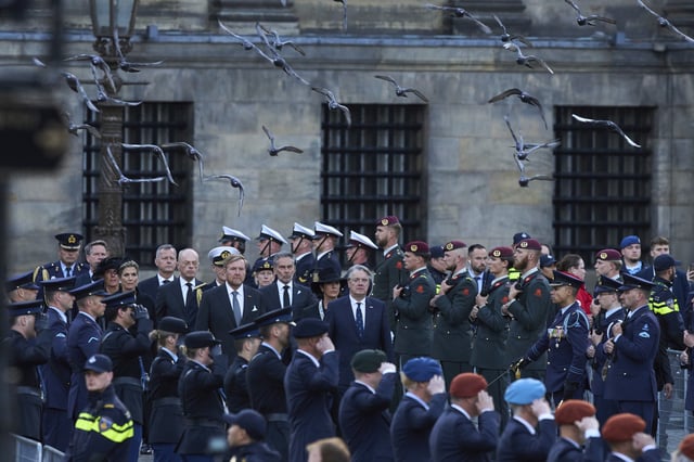 Pigeons fly as Dutch King Willem-Alexander and Queen Maxima arrive to lay a wreath during a solemn annual national service to commemorate the war dead in Amsterdam, Netherlands, Sunday, May 4, 2025. (AP Photo/Peter Dejong)