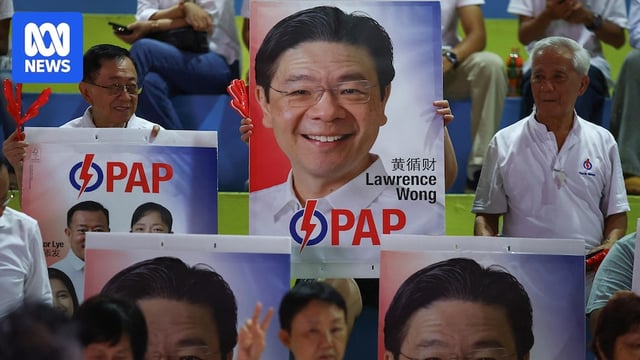 People's Action Party supporters hold signs in support of Singapore's Prime Minister Lawrence Wong