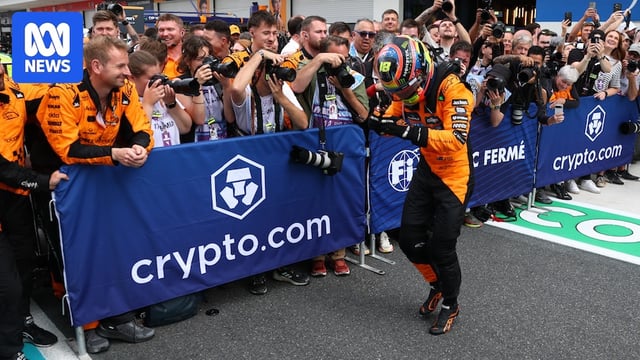Oscar Piastri attempts the Griddy in front of his team members and crowd after a race