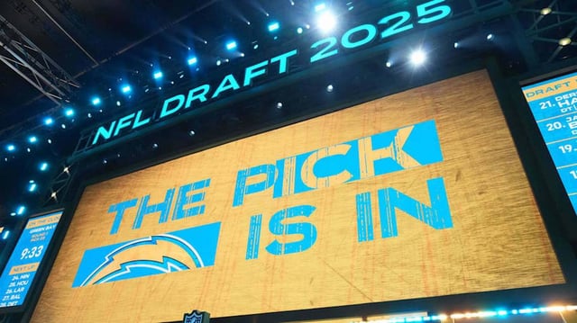 The Los Angeles Chargers logo is projected on the video board during the NFL Draft at Lambeau Field.