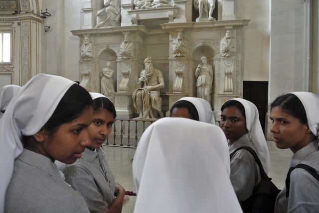 FILE - Nuns talk in front of Italian Renaissance artist Michelangelo Buonarroti's Moses statue, part of a funerary monument he designed for Pope Julius II inside San Pietro in Vincoli Basilica in Rome, July 2, 2013. (AP Photo/Gregorio Borgia, File)