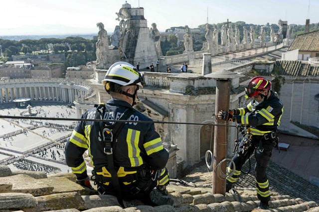 Les pompiers du Vatican installent la cheminée sur le toit de la chapelle Sixtine au Vatican, le 2 mai 2025, avant le début du conclave. De cette cheminée sortira la fumée blanche qui signalera l'élection d'un nouveau pape.
