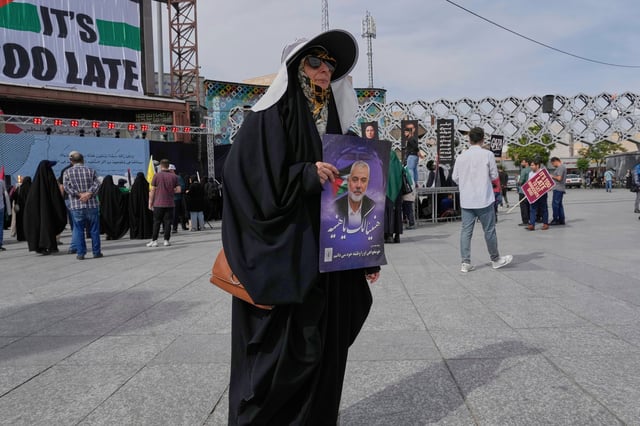 A demonstrator holds a poster of late Hamas leader Ismail Haniyeh with Arabic writing: "Congratulations Haniyeh!" during a pro-Palestinian gathering in Tehran, Iran, Friday, May 2, 2025. (AP Photo/Vahid Salemi)