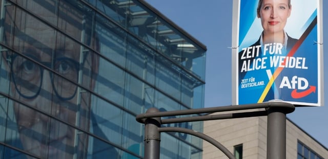 Une affiche électorale de la candidate et co-dirigeante du parti d'extrême droite Alternative pour l'Allemagne (AfD), Alice Weidel (d), devant le siège du parti chrétien-démocrate CDU avec une photo géante de son dirigeant Friedrich Merz sur sa façade, le 24 février 2025 à Berlin