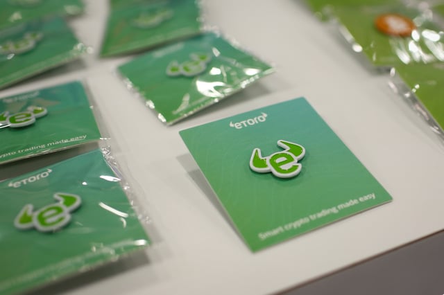 Pins depicting the logo of EToro are seen at a stand during the Bitcoin Conference 2022 in Miami Beach, Florida, U.S. April 6, 2022. REUTERS/Marco Bello/File photo