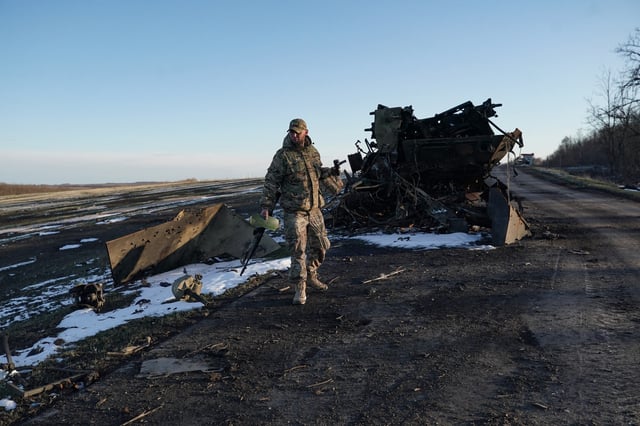 A fighter of the Chechen Akhmat battalion walks near destroyed military vehicles on a road near the village of Kazachya Loknya, which was previously held by Ukrainian troops and recently retaken by Russia&#39;s armed forces, in the Sudzha district of the Kursk region on March 18, 2025.