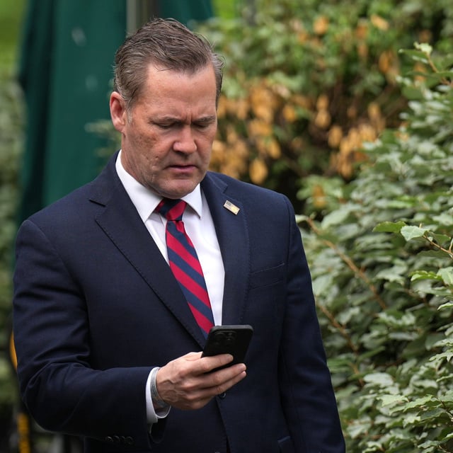 National Security Advisor Michael Waltz looks at his phone