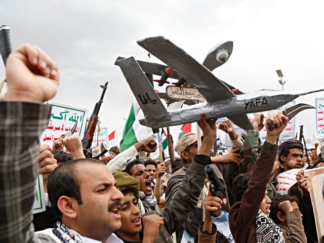 SANA'A, YEMEN - MAY 2: Yemenis brandish their weapons and mock drones while they chant slogans during a mass protest held against the US airstrikes that killed civilians in the country, including the African refugees, and in solidarity with the people in the Gaza Strip on May 2, 2025 in Sana'a, Yemen. The US has continued an airstrike campaign known as "Operation Rough Rider," targeting Yemen's Iran-backed Houthi rebel group, following negotiations between the Trump administration and Tehran over Iran's nuclear program. (Photo by Mohammed Hamoud/Getty Images)