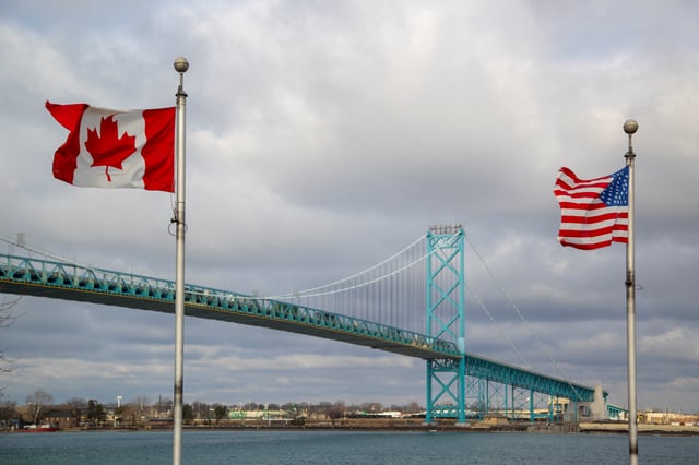 Flags wave in the wind near the Ambassador Bridge which connects Windsor, Ontario, Canada, and Detroit, Michigan, U.S., in Windsor, Ontario, Canada February 4, 2025. REUTERS/Carlos Osorio/File Photo