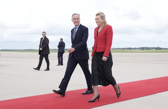 Prime Minister Mark Carney speaks with US Acting Chief of Protocol Abby Jones Monday May 5, 2025 as he arrives in Washington, D.C. THE CANADIAN PRESS/Adrian Wyld