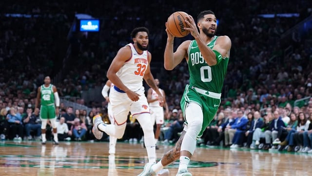 Oct 22, 2024; Boston, Massachusetts, USA; Boston Celtics forward Jayson Tatum (0) returns the ball to score against New York Knicks center Karl-Anthony Towns (32) in the first quarter at TD Garden. Mandatory Credit: David Butler II-Imagn Images