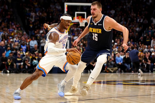 Shai Gilgeous-Alexander #2 of the Oklahoma City Thunder drives against Nikola Jokic #15 of the Denver Nuggets at Ball Arena on November 6, 2024 in Denver, Colorado.