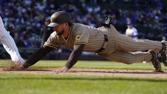 Apr 6, 2025; Chicago, Illinois, USA; San Diego Padres outfielder Jackson Merrill (3) dive into first base against the Chicago Cubs during the eighth inning at Wrigley Field. Mandatory Credit: David Banks-Imagn Images