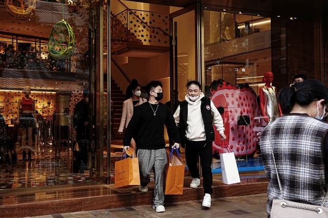 Shoppers walk out of a luxury store at Tsim Sha Tsui district in Hong Kong, China February 15, 2023. REUTERS/Lam Yik/File Photo