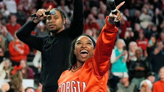 Simone Biles calls the Dawg with her husband Jonathan Owens during a NCAA gymnastics meet against Boise State in Athens, Ga., on Friday, Jan. 17, 2024. Georgia won 196.825 to 193.600.