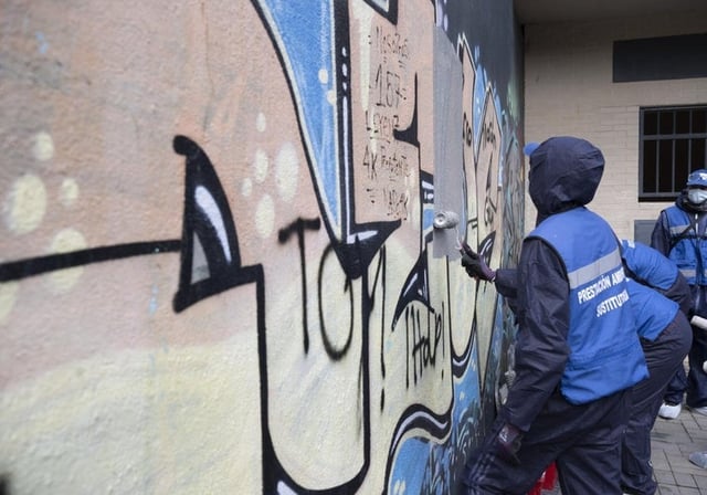 Un grupo de grafiteros limpiando una pared de Bravo Murillo