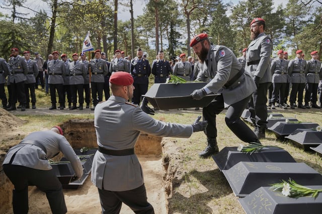 German soldiers carry the small coffins with the remains of fallen German soldiers of WWII to the grave during a funeral service at a memorial site for fallen soldiers in Halbe, Germany, Wednesday, April 30, 2025. (AP Photo/Ebrahim Noroozi)
