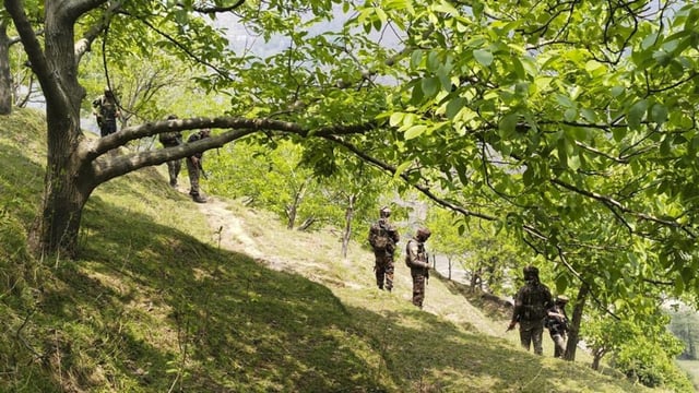 Security personnel keep vigil after a brief exchange of fire took place between terrorists and security forces in Lasana village of Surankote.