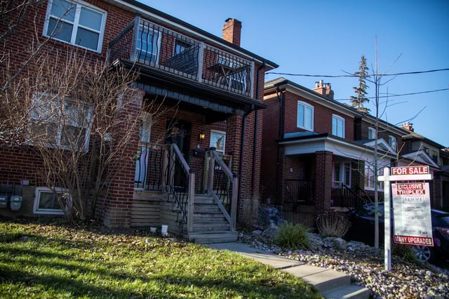 A for sale sign is displayed outside a home in Toronto, Ontario in Toronto, Ontario, Canada December 13, 2021.  REUTERS/Carlos Osorio/File Photo