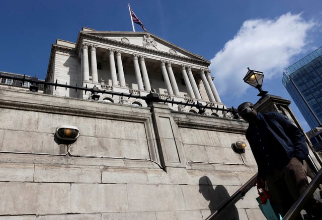 A man walks down the stairs as the Bank of England building is seen on the backdrop in London, Britain, April 14, 2025. REUTERS/Carlos Jasso/File Photo